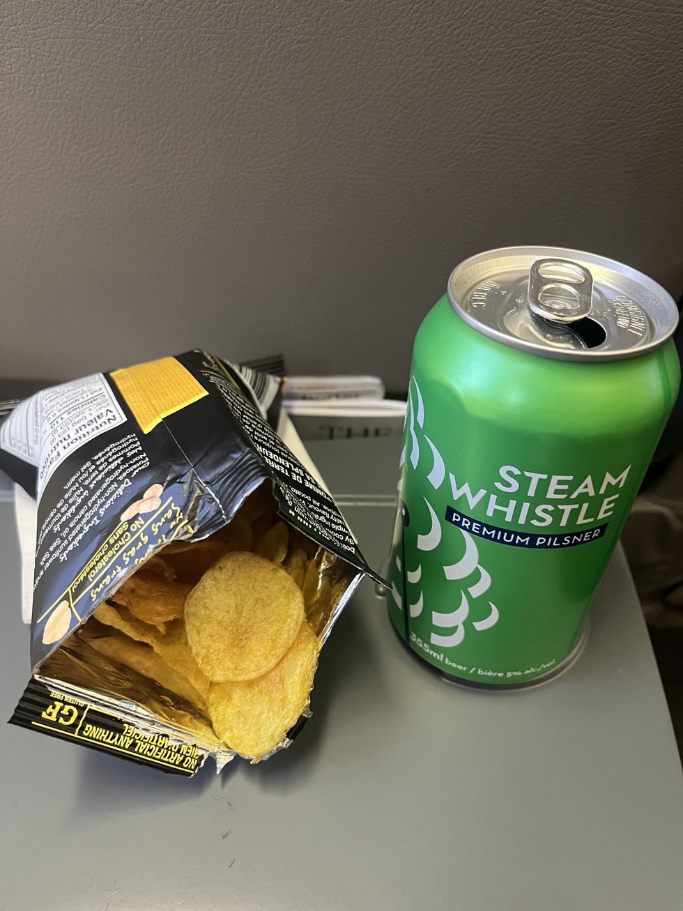 A bag of chips and a can of Steam Whistle beer.