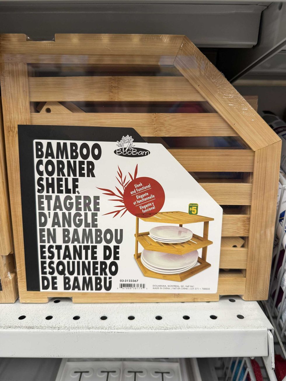 A bamboo corner shelf with a photo of plates stacked on it on a store shelf.