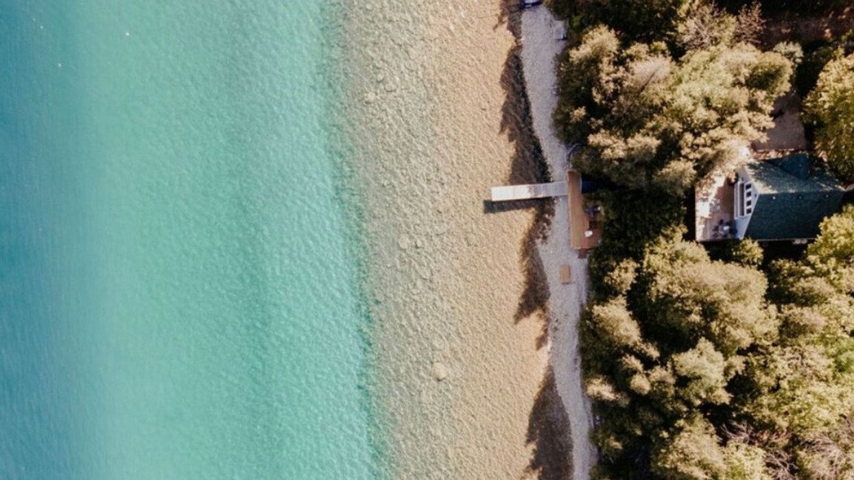 A beach house sitting on turquoise water.