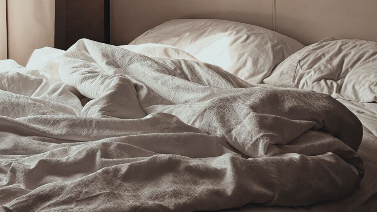 A bed with messy sheets.