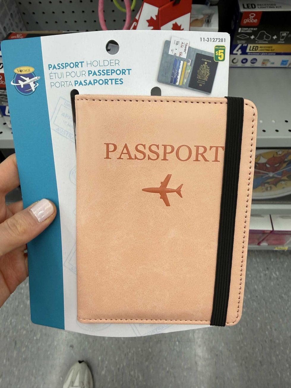 A beige passport holder with an airplane design on it.