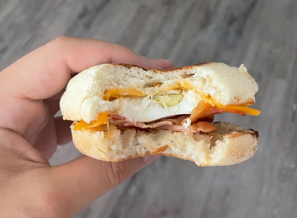 A bitten maple bacon breakfast sandwich from Tim Hortons.