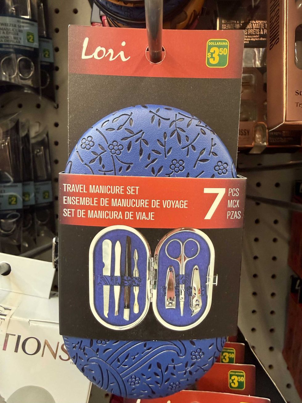 A blue and black container with a red and black label on the front that says travel manicure set and shows an image of what's inside.