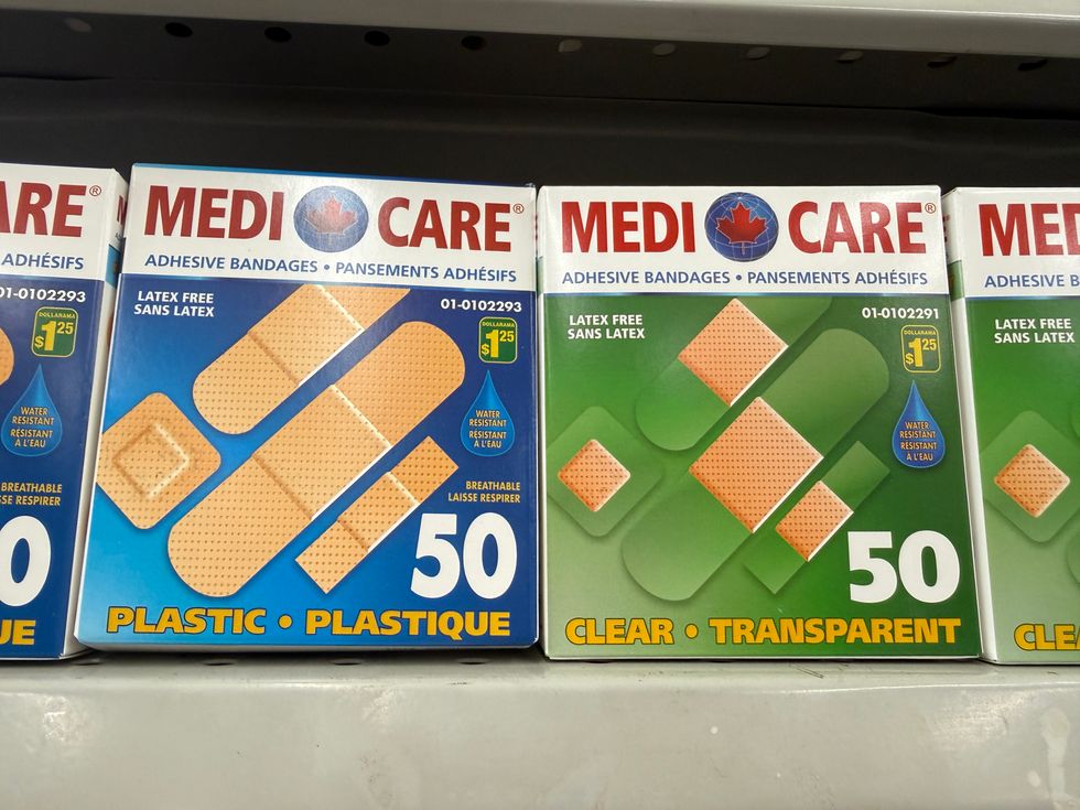 A blue and white box with brown bandages on the front next to a green and white box of clear and brown bandages on the front.