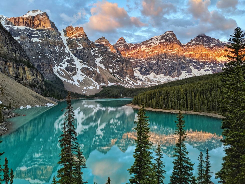 A blue lake surrounded by trees and mountains in Banff National Park.