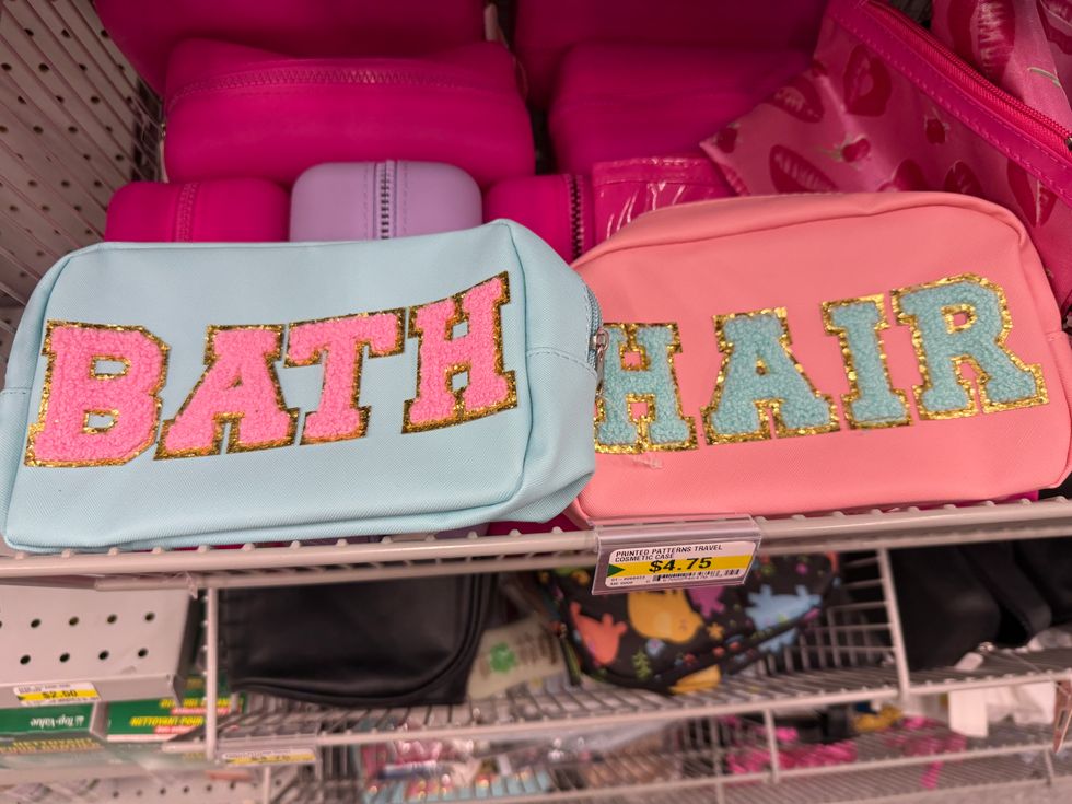 A blue toiletry bag that says bath on it next to a pink toiletry bag that says hair on it.