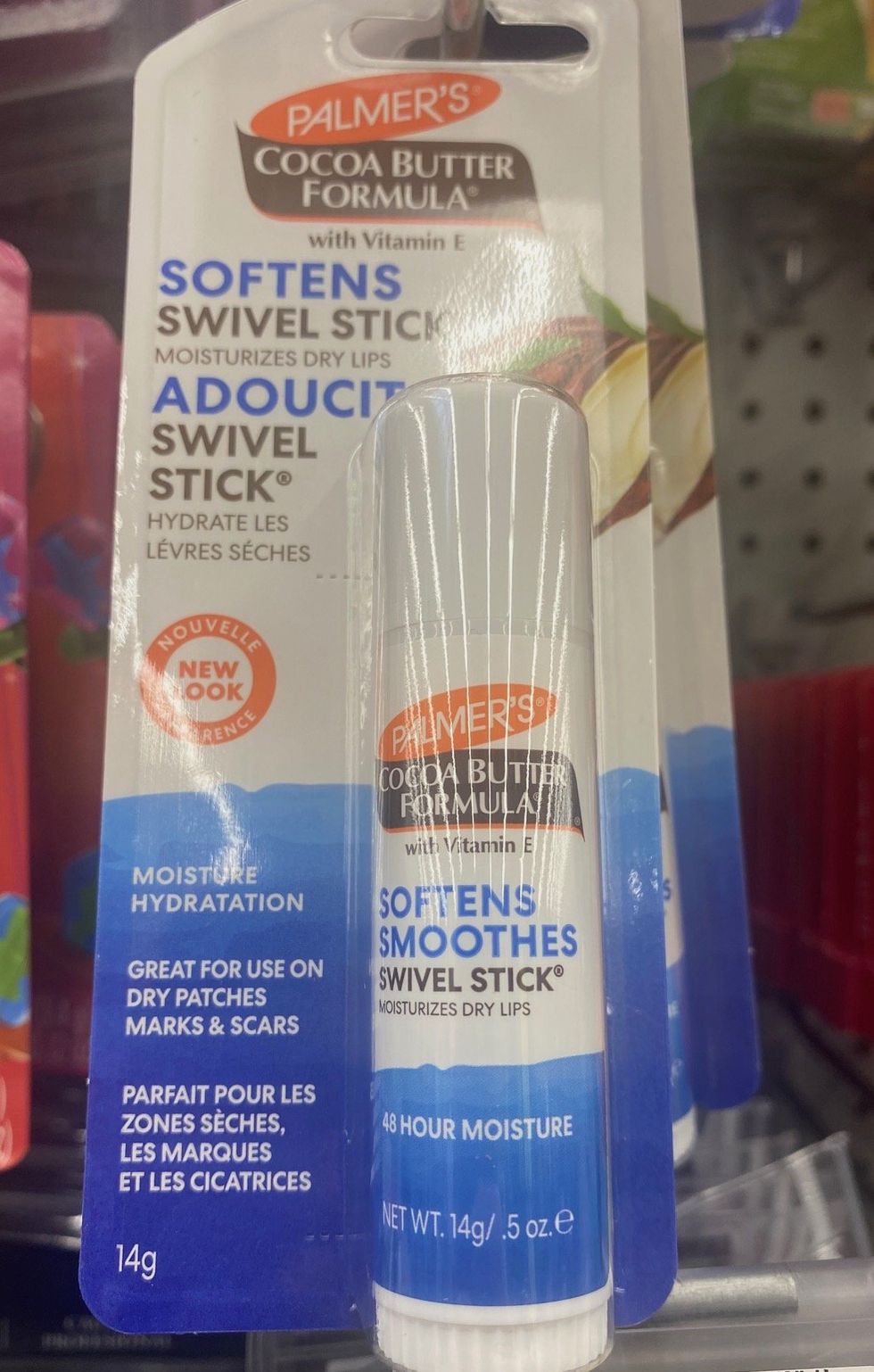 A blue, white and orange tube of Palmer's Cocoa Butter Swivel stick hanging on a store shelf.
