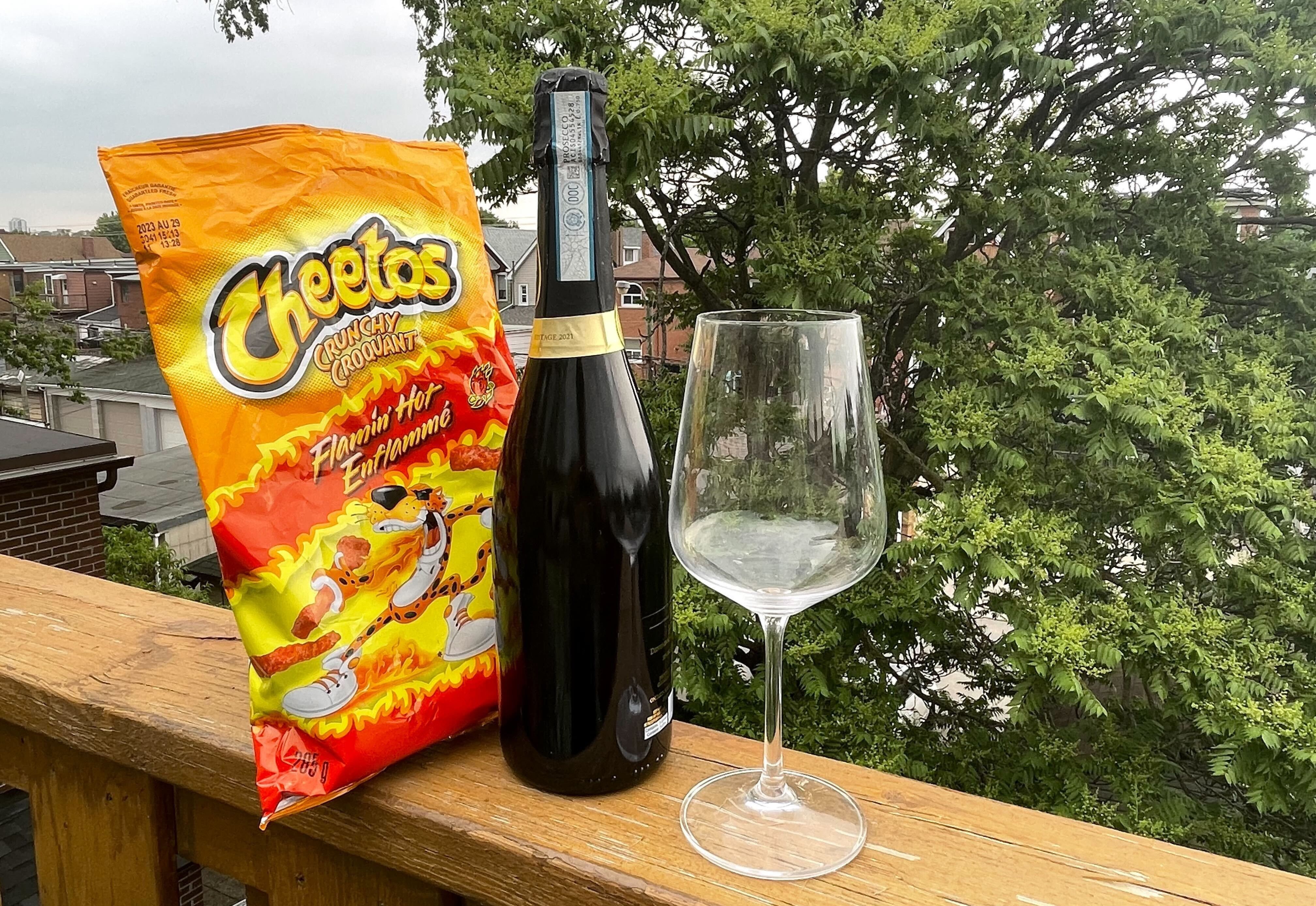 A bottle of wine with Flamin' Hot Cheetos.