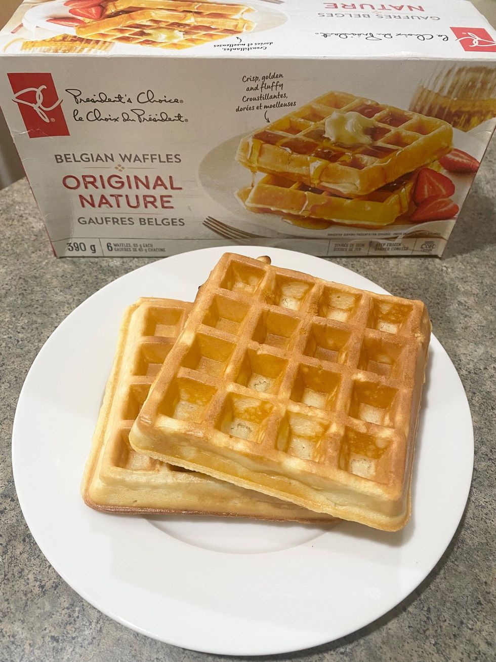 A box of President's Choice frozen waffles and two toasted waffles on a plate.