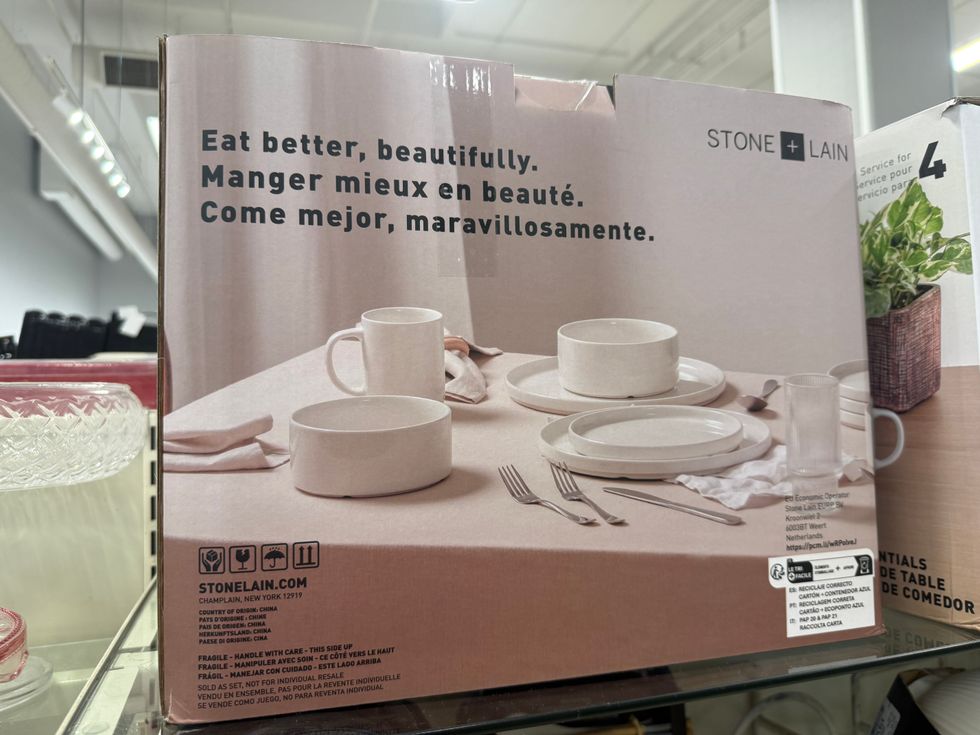 A box with a photo of white plates, bowls and dishes on it and a label reading Stone + Lain Eat better, beautifully.