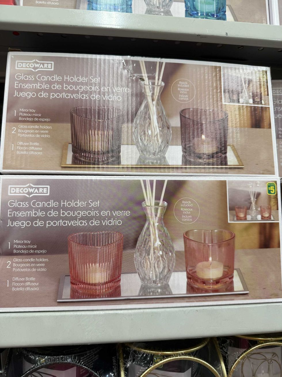 A box with a picture of two heart-shaped glass candle holders and a glass diffuser bottle in the middle on a mirror tray.