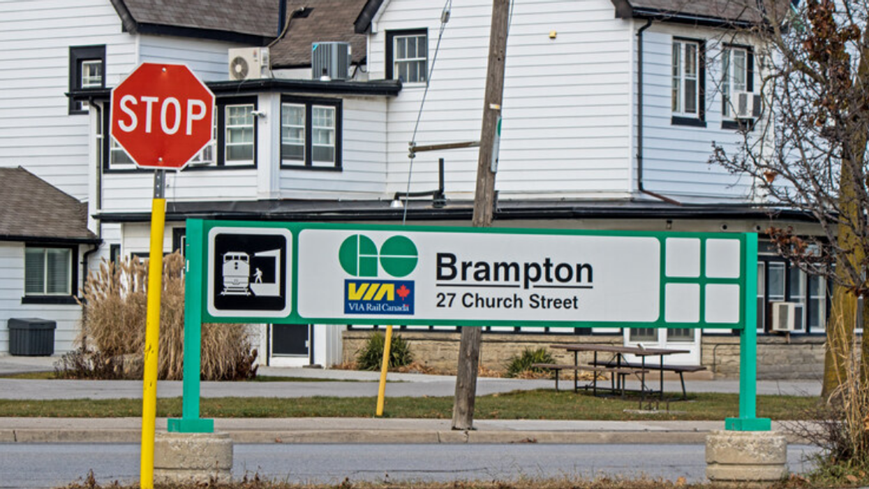 A Brampton GO Station sign beside a stop sign in a neighbourhood.