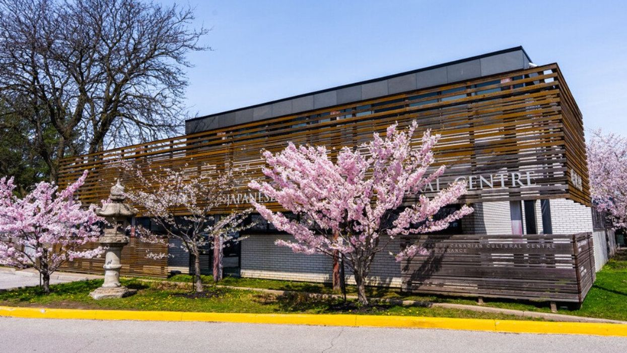 A building with cherry blossoms outside of it.