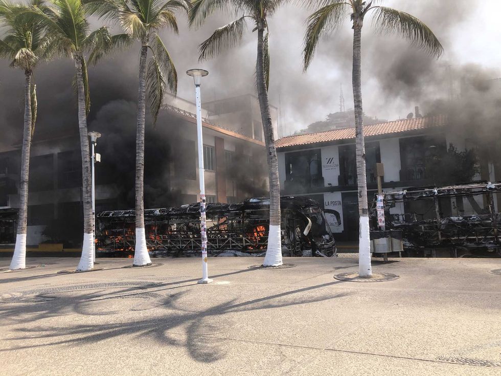 A burned-out bus is shown near the boardwalk in the tourist area of Puerto Vallarta, Mexico