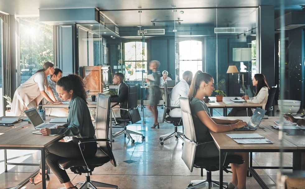 A busy office space with people working at laptops. 