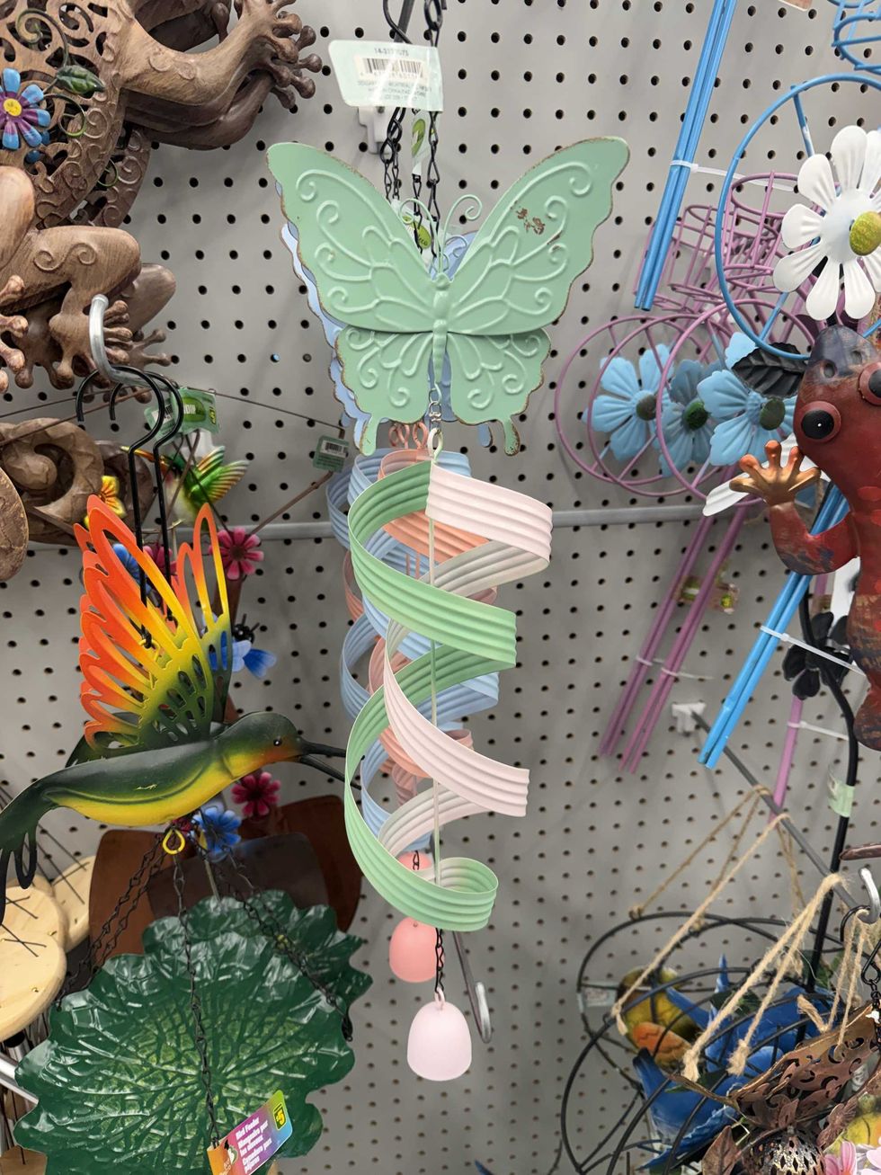 A butterfly wind chime hanging on a store shelf.