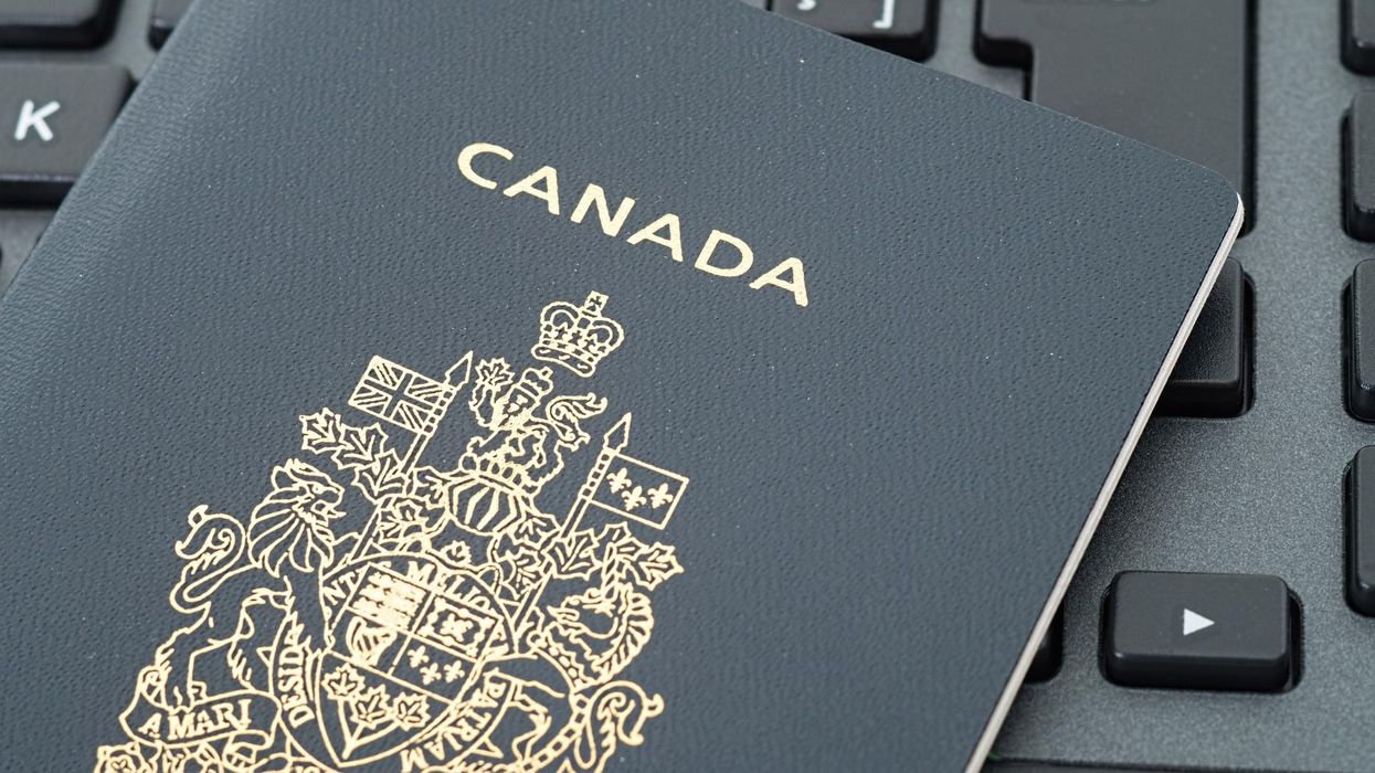 A Canadian passport on top of a keyboard.