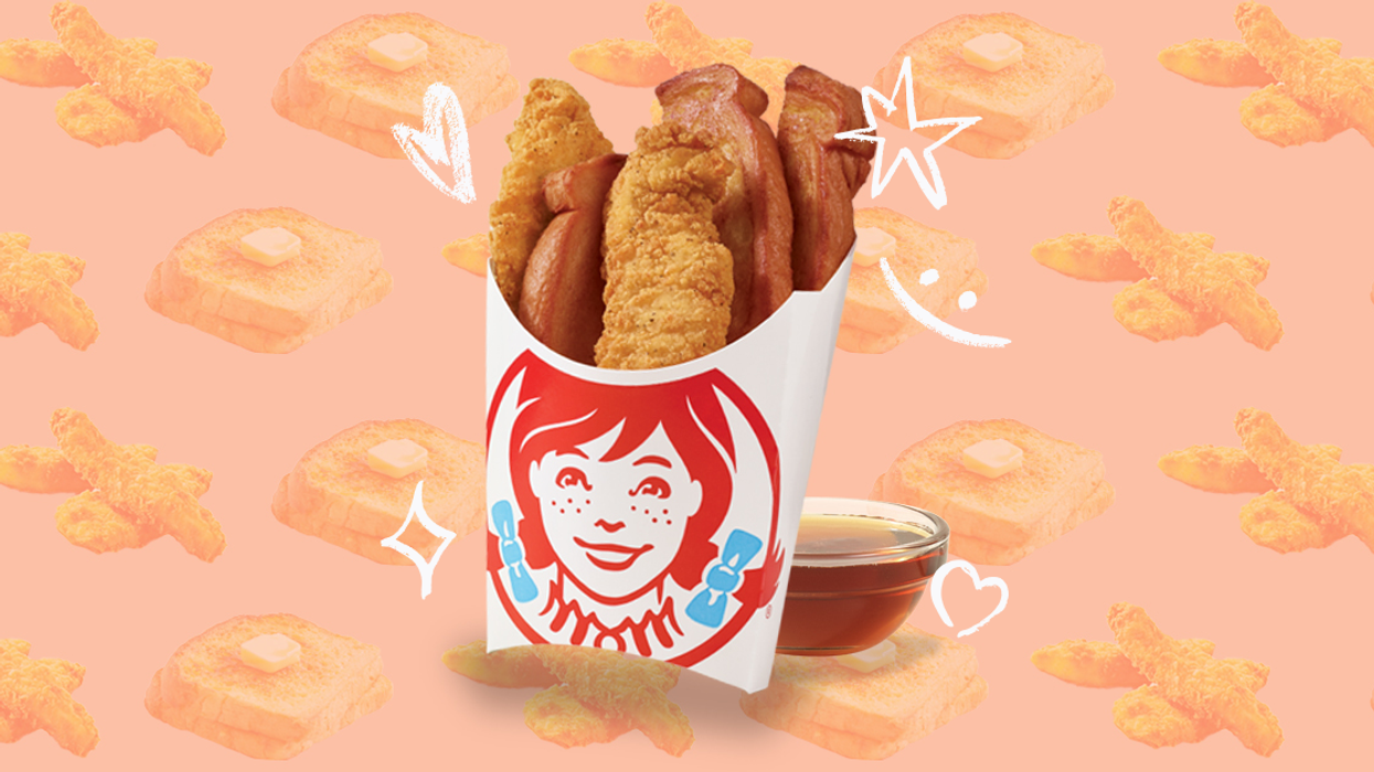 A cardboard carton featuring the Wendy's Canada logo and containing a combination of crispy chicken strips and French Toast Sticks next to a small glass bowl of syrup against a peach coloured background with a repeating pattern of French toast slices and chicken strips.