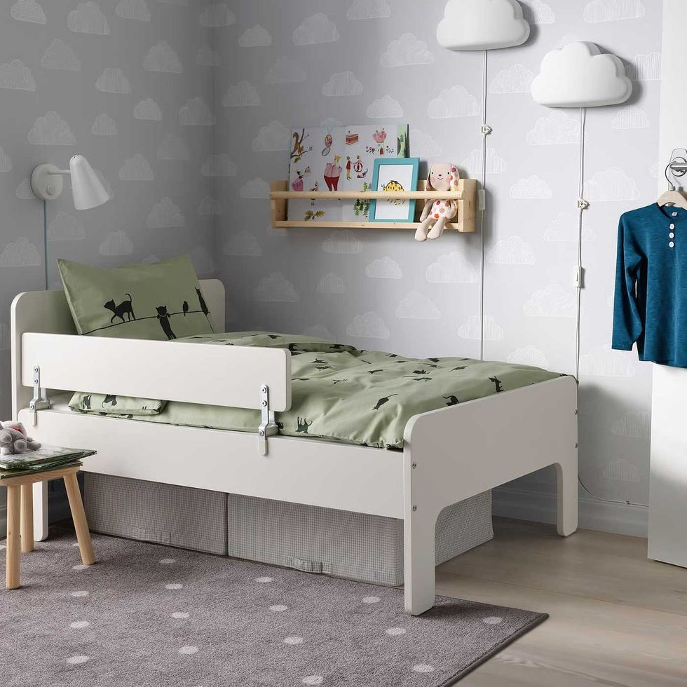 A child's bedroom with a white bed featuring a white guardrail.