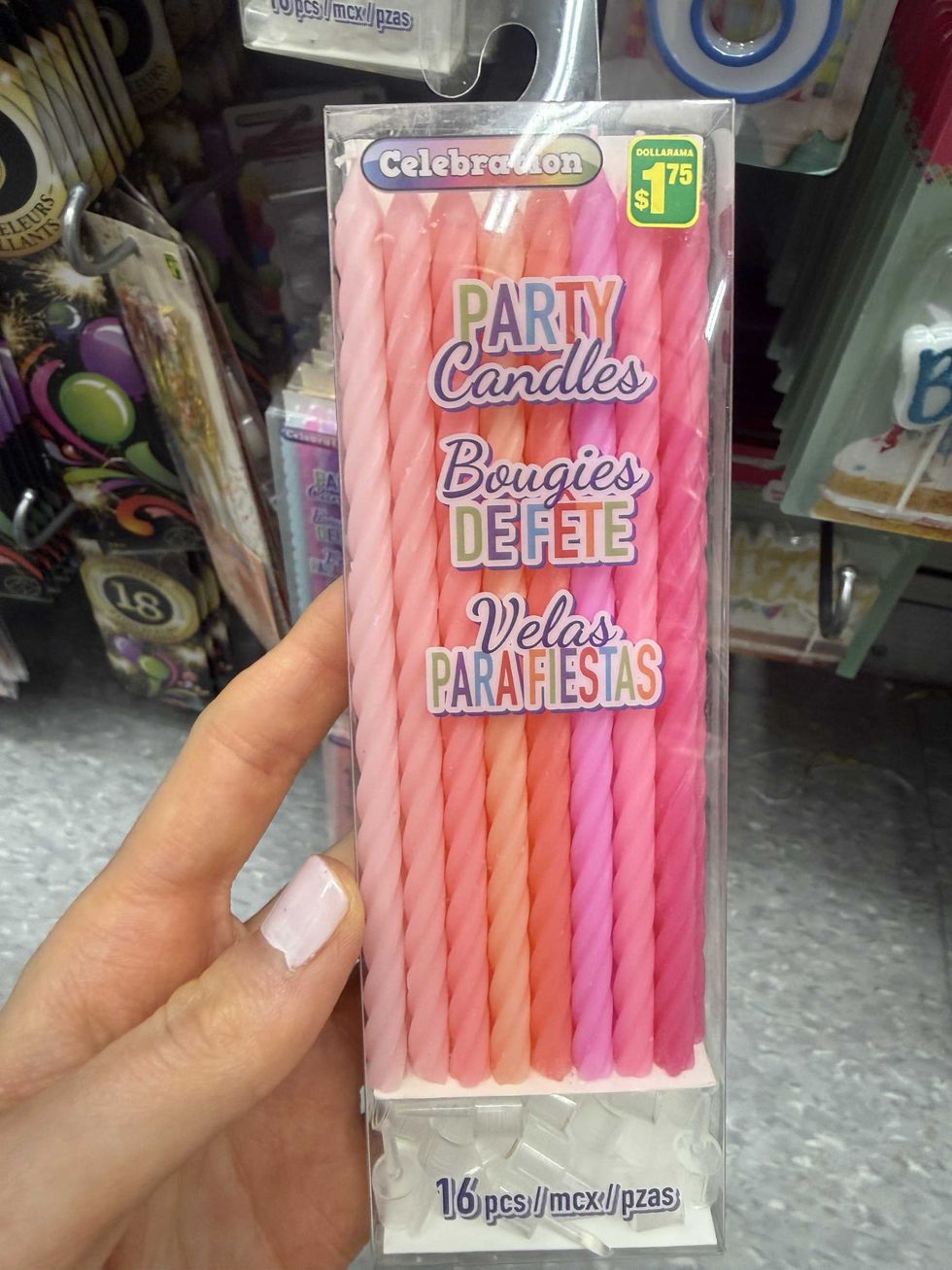 A clear box with candles inside in various shades of pink.