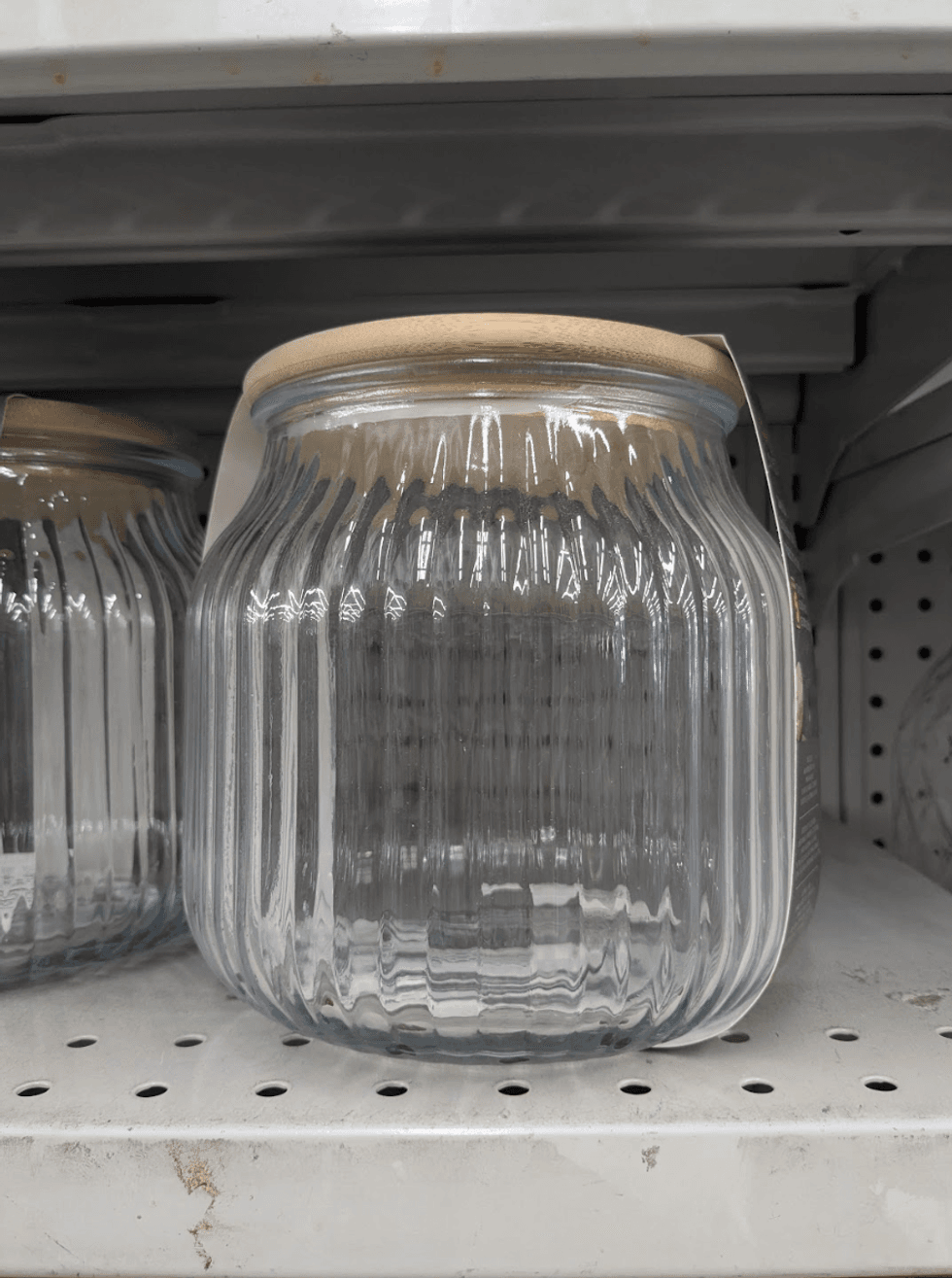 A clear glass storage jar with a sealed lid