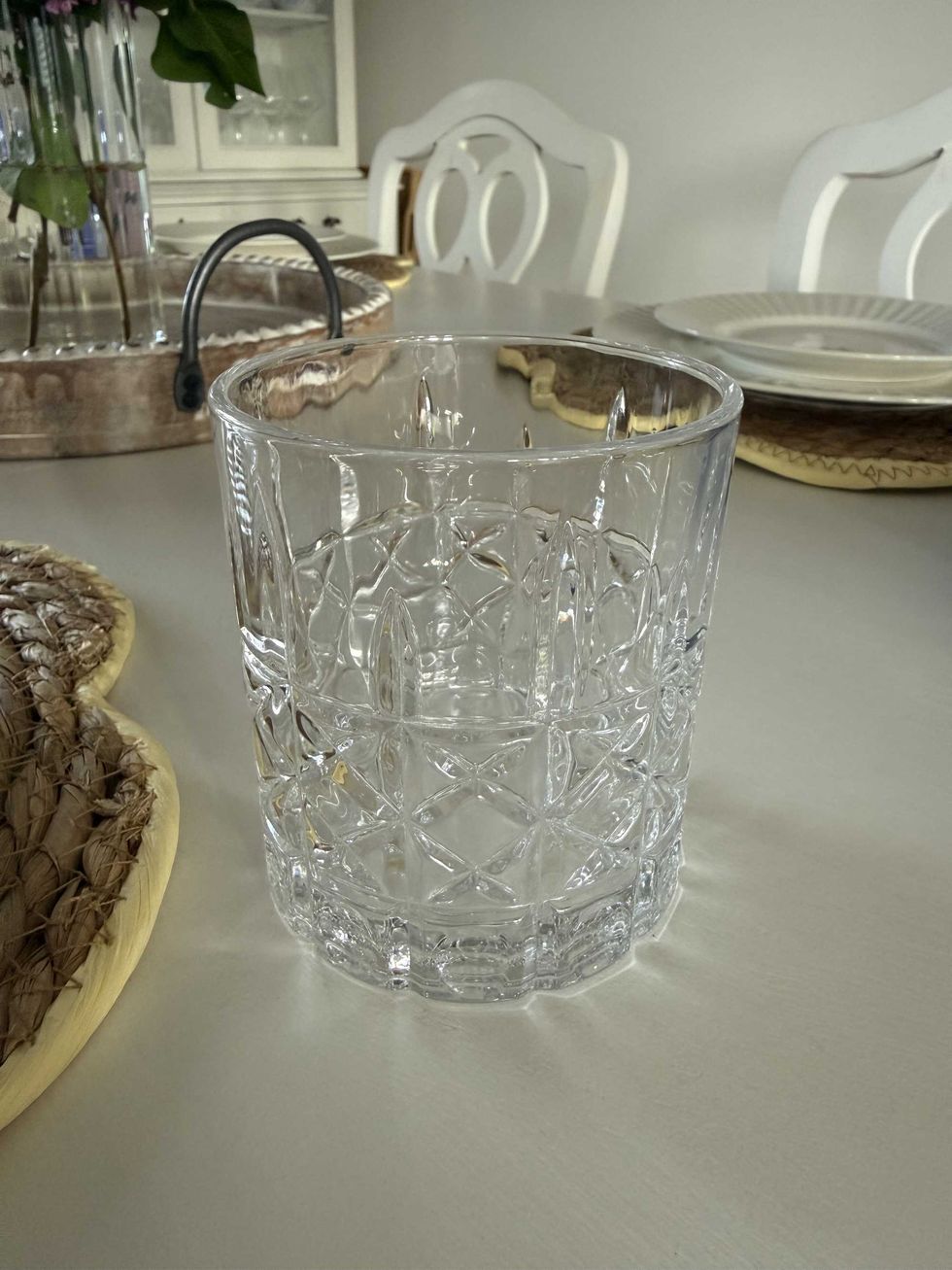 A clear white drinking glass on a white dining table.