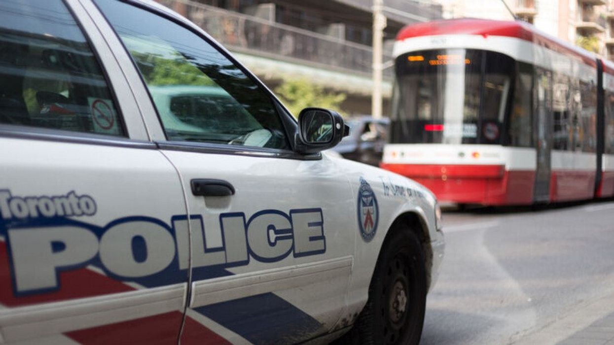 A close-up of a Toronto police car and a street car on a street.