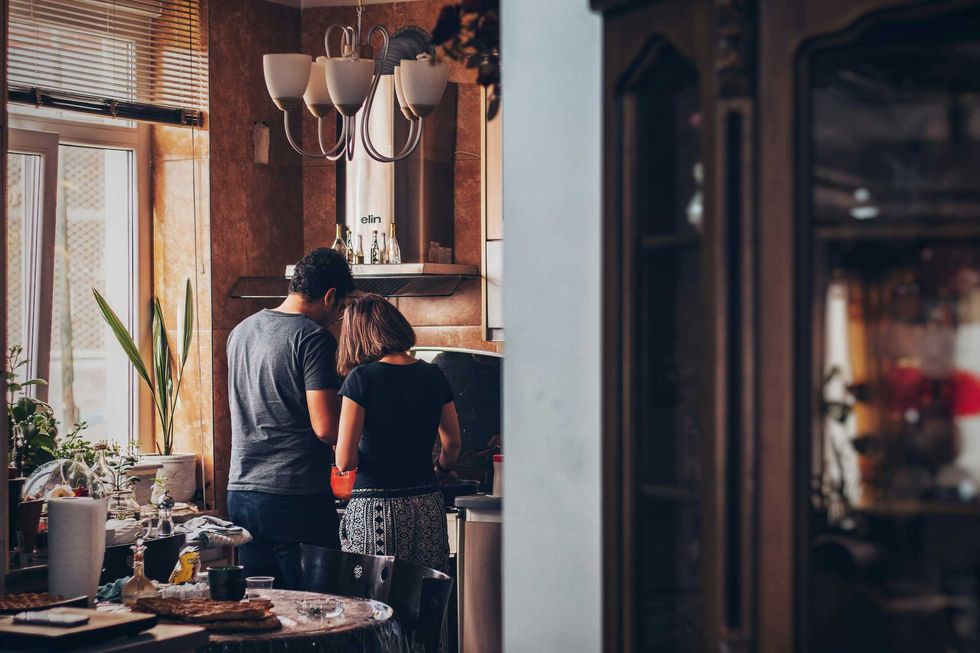 A couple cooking in a kitchen.