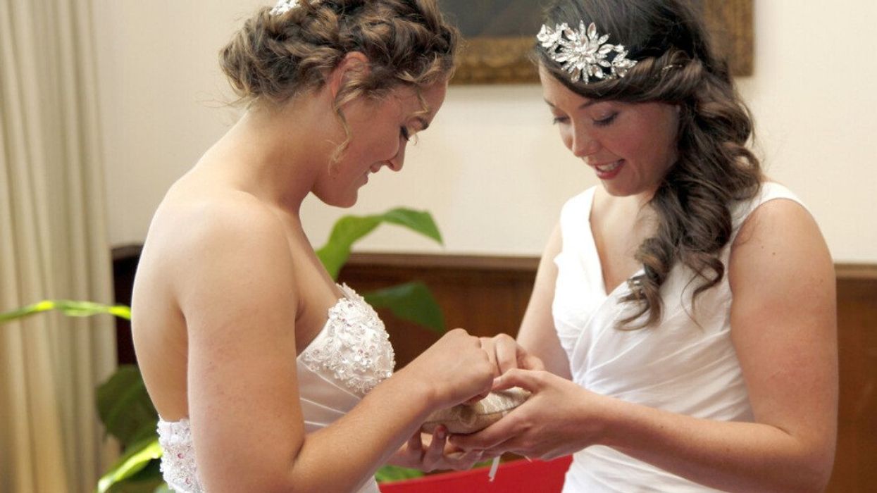 A couple exchanging rings at a courthouse.