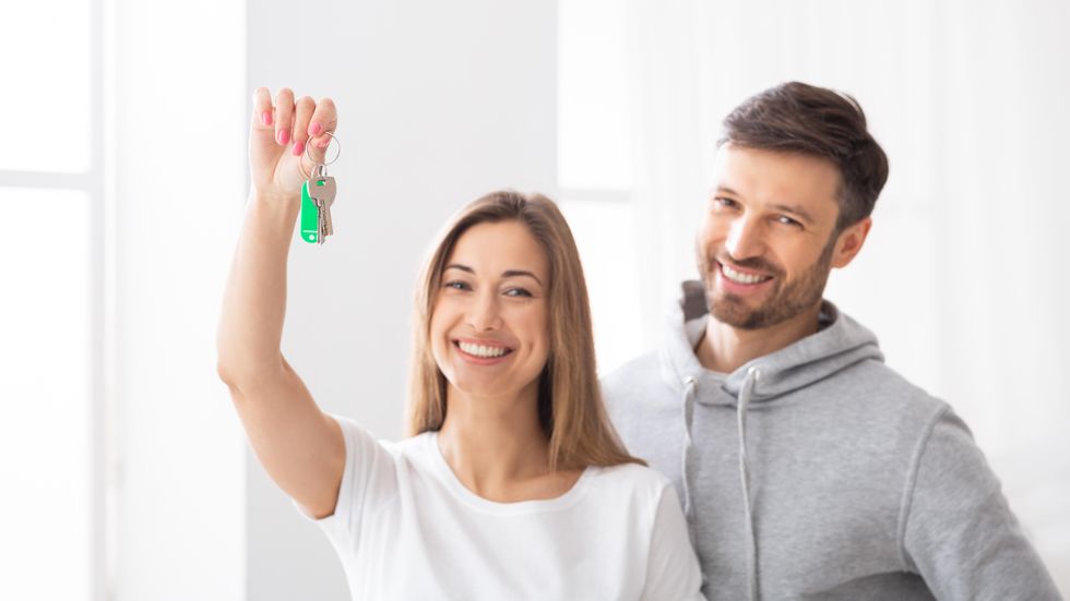 A couple holding the keys to their new house.