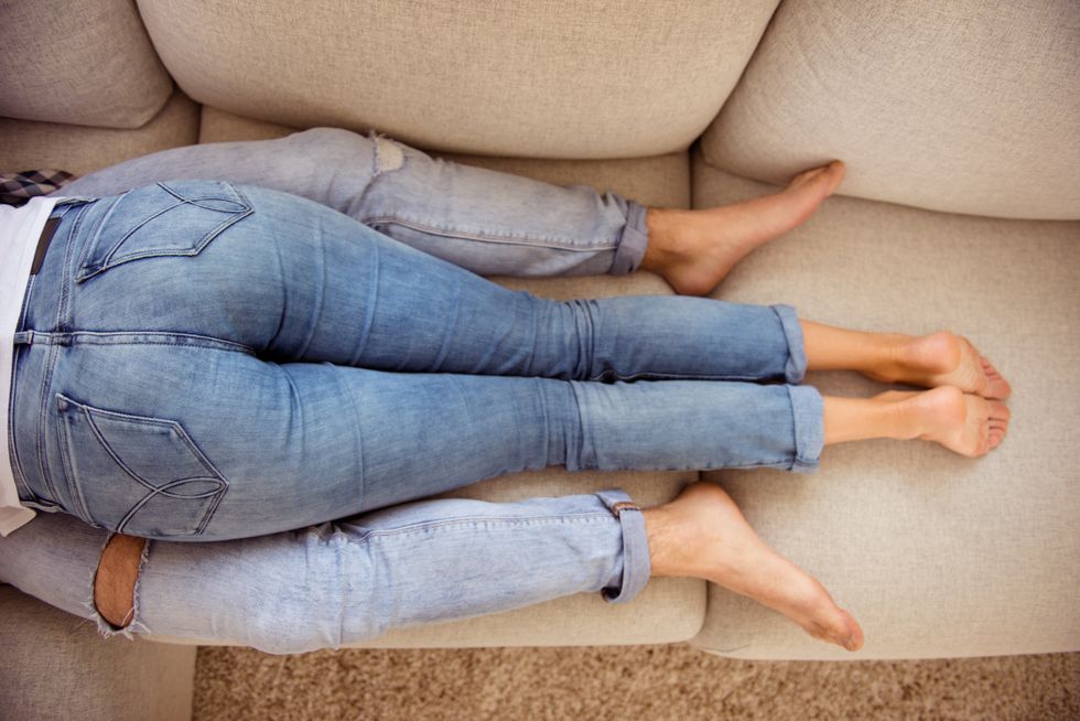 A couple laying on the couch.
