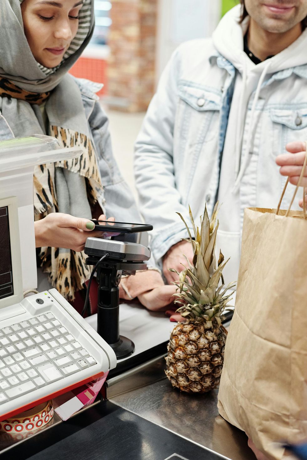 A couple paying for groceries at a store.