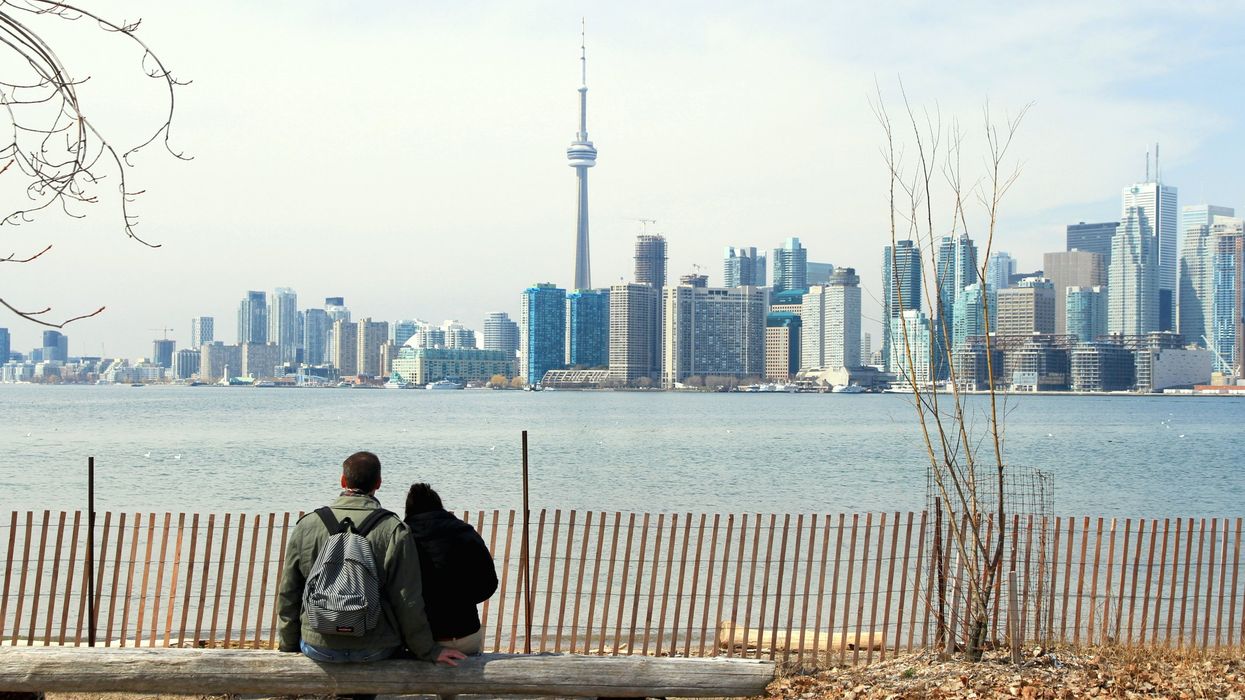 A couple sitting in front of the Toronto skyline.