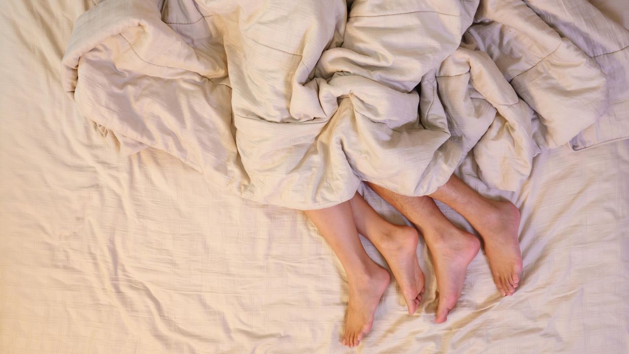 A couples feet in bed.