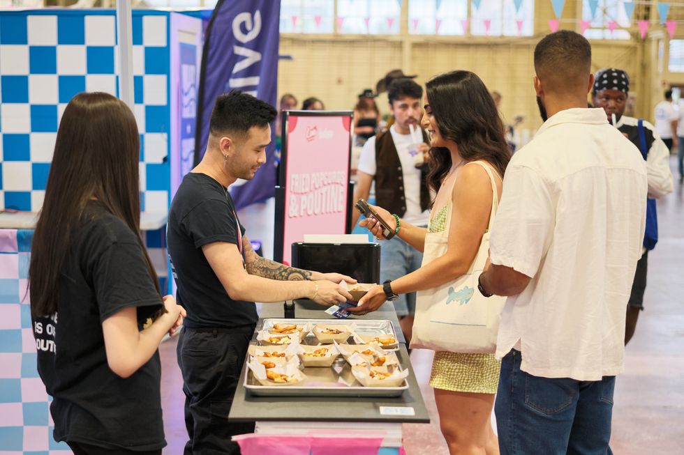 A cownty fair guests receives some tasty eats from a vendor.