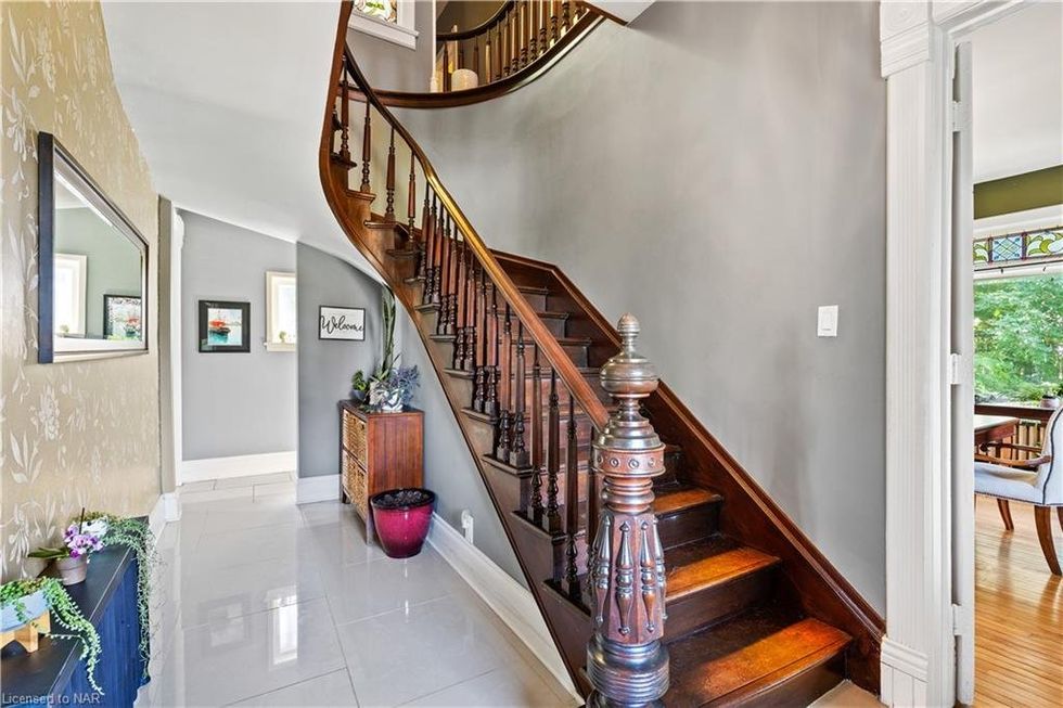 A curving wooden staircase in an entranceway.