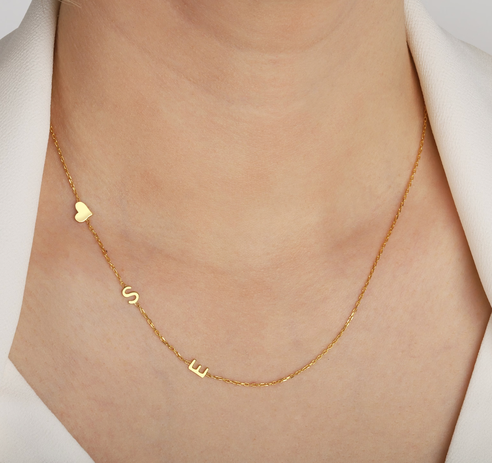 A custom letter necklace with the letters "S" and "E" and a gold heart.