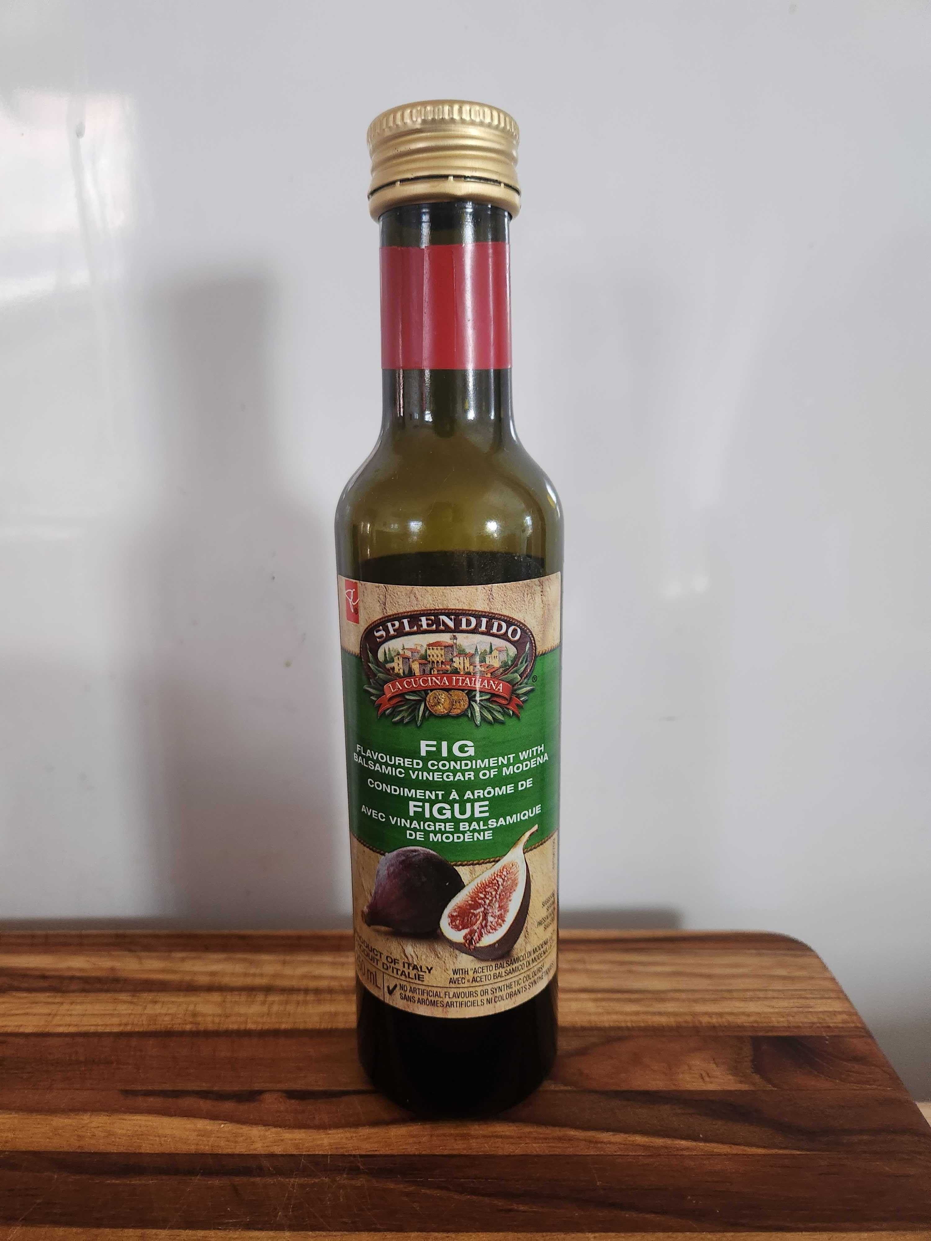 A dark bottle with a green label on a wood cutting board.