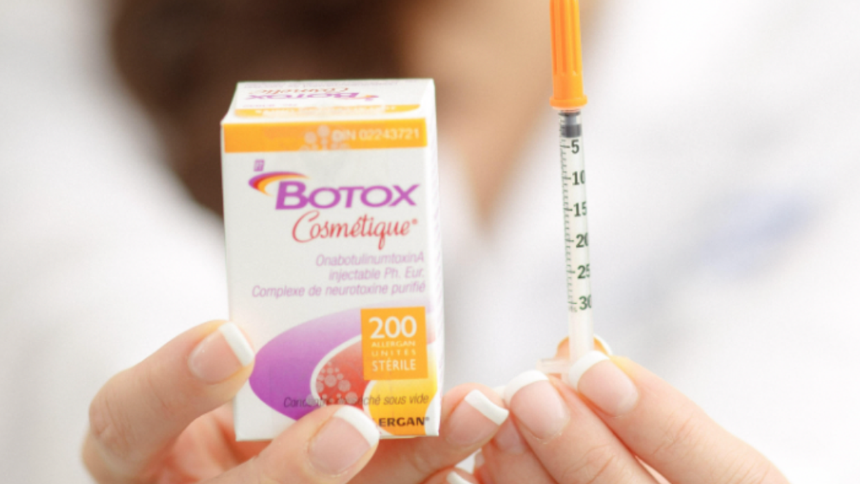 A doctor holding a box of botox and a syringe.