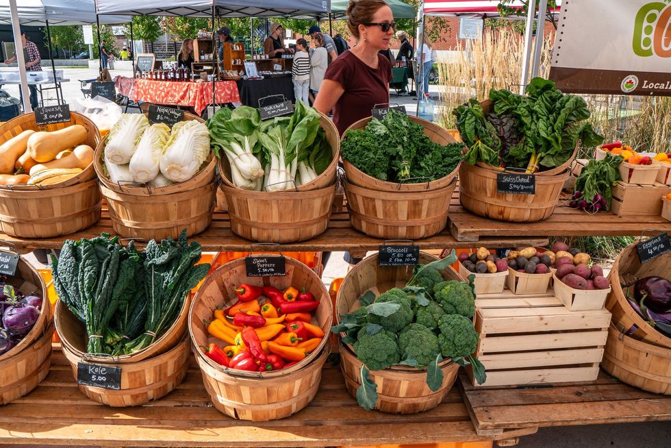 A farmers market stand displaying fresh, colourful vegetables. 