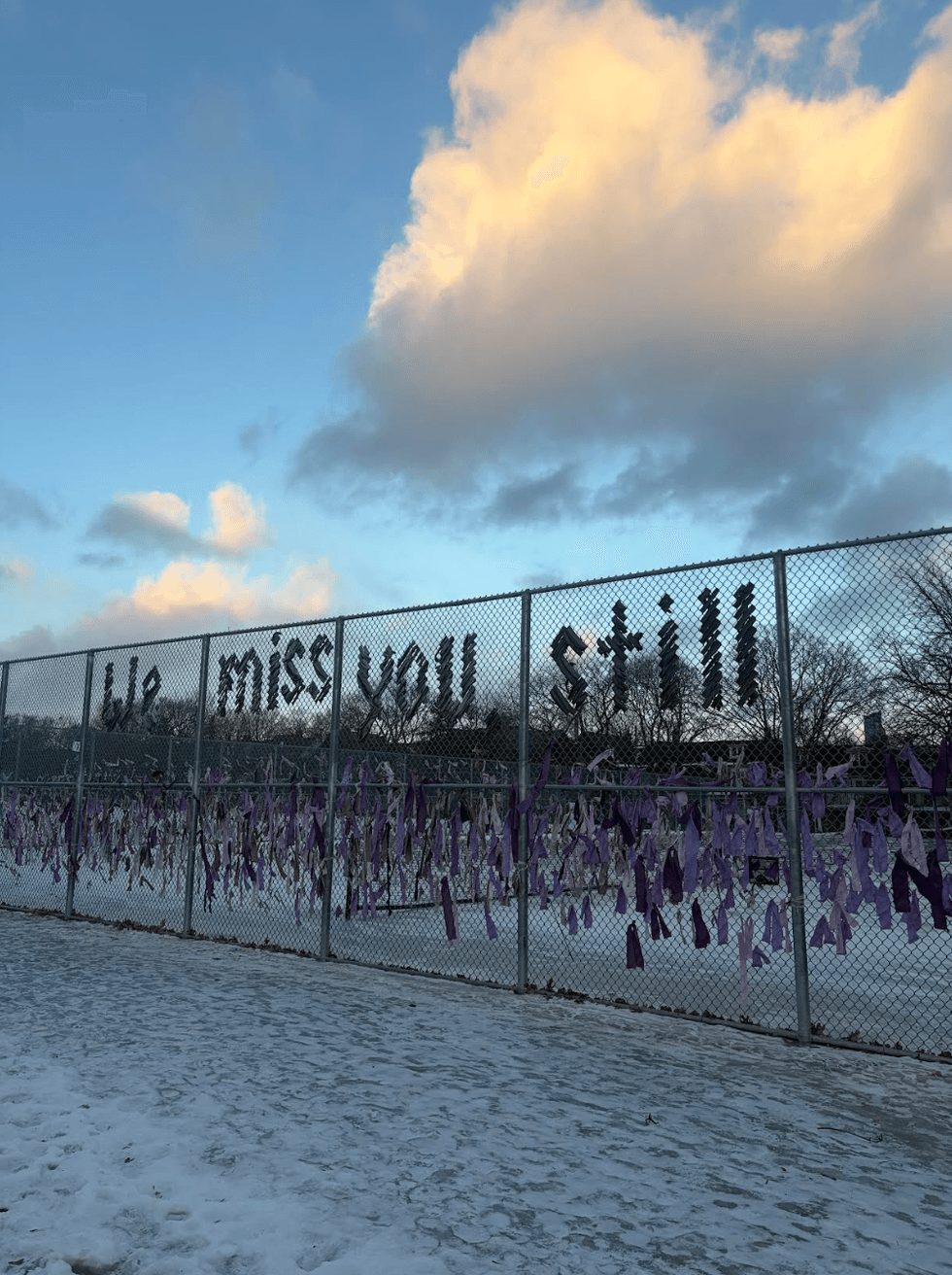 A fence with writing that says we miss you still
