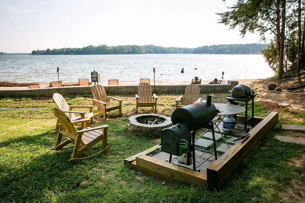A fire pit and lounge chairs overlooking the water.