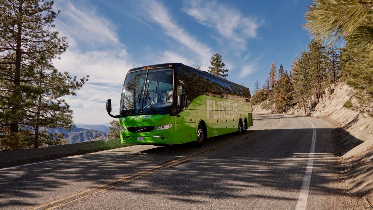 A FlixBus travelling on a picturesque road.