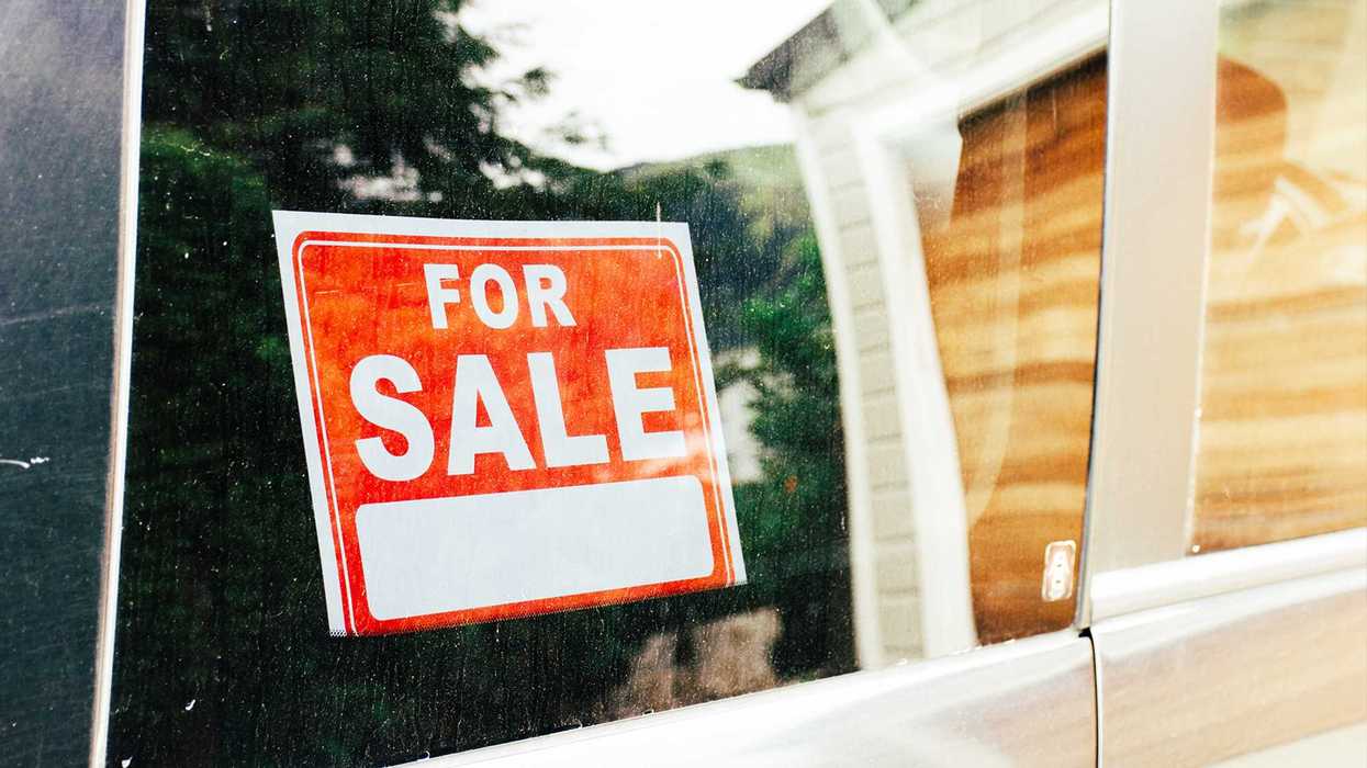 A "for sale" sign in the window of a used car.