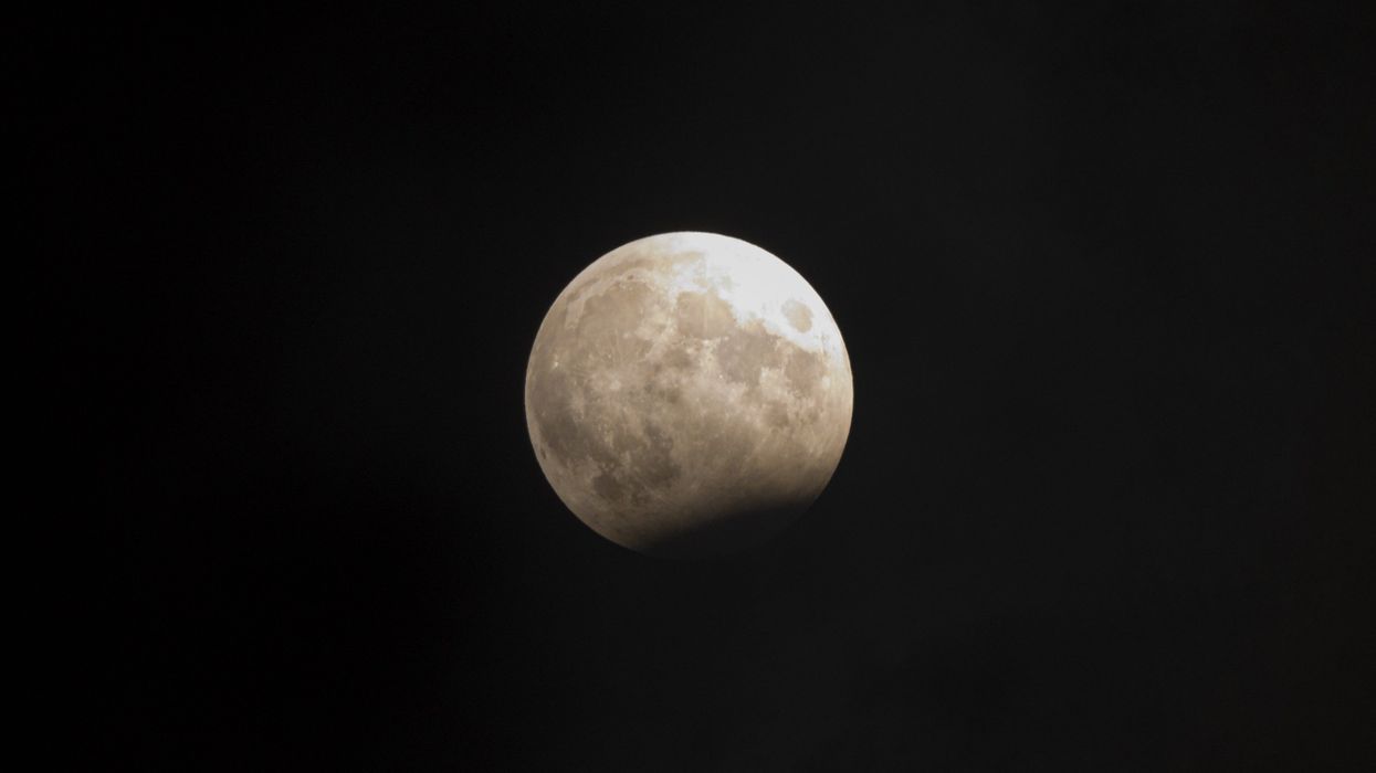 A full moon in a dark sky, partially obstructed by the shadow of the Earth.