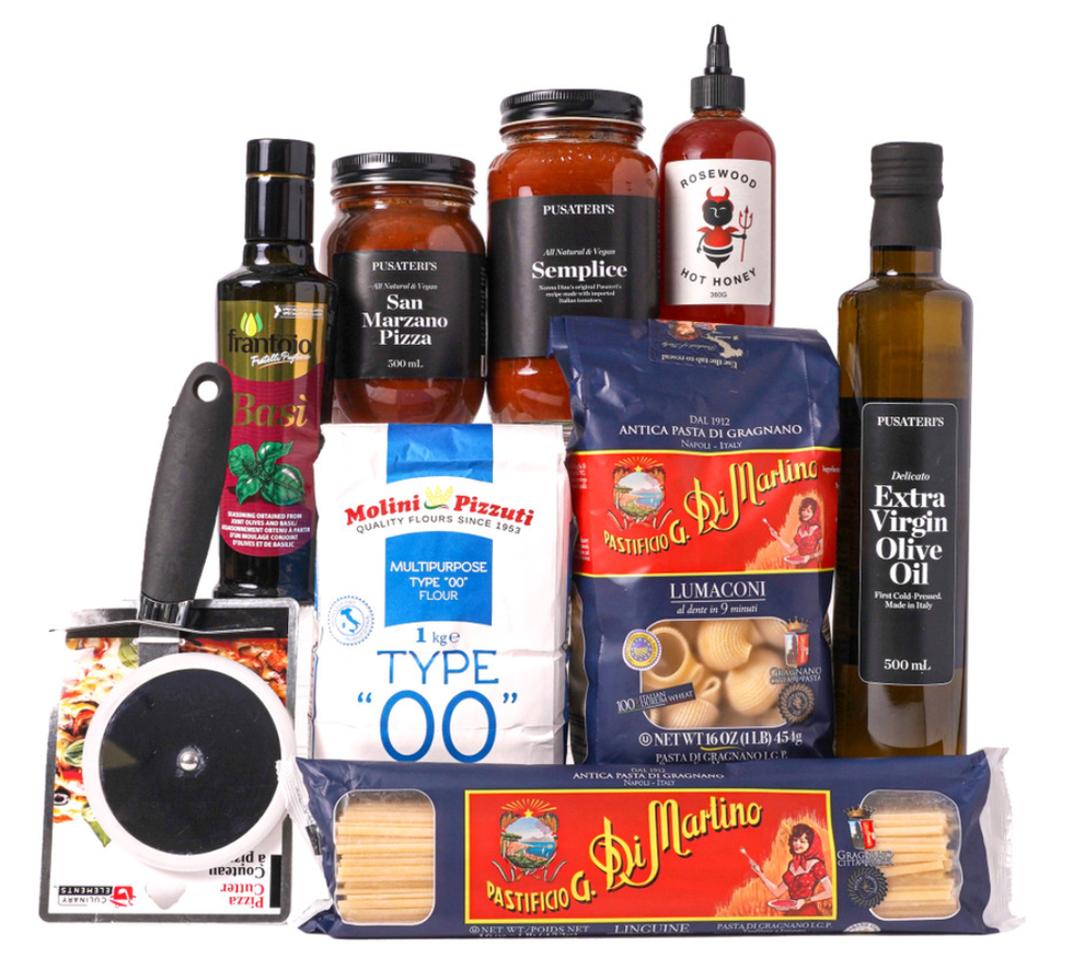 A gift basket with an assortment of items like pasta, extra virgin olive oil, a pizza cutter, flour and pizza sauce.