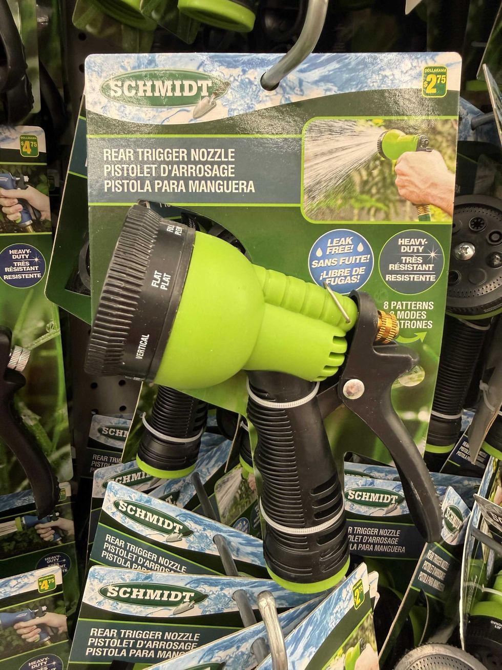 A green and black hose nozzle hanging on a store shelf with the packaging reading "leak free" and "heavy duty."