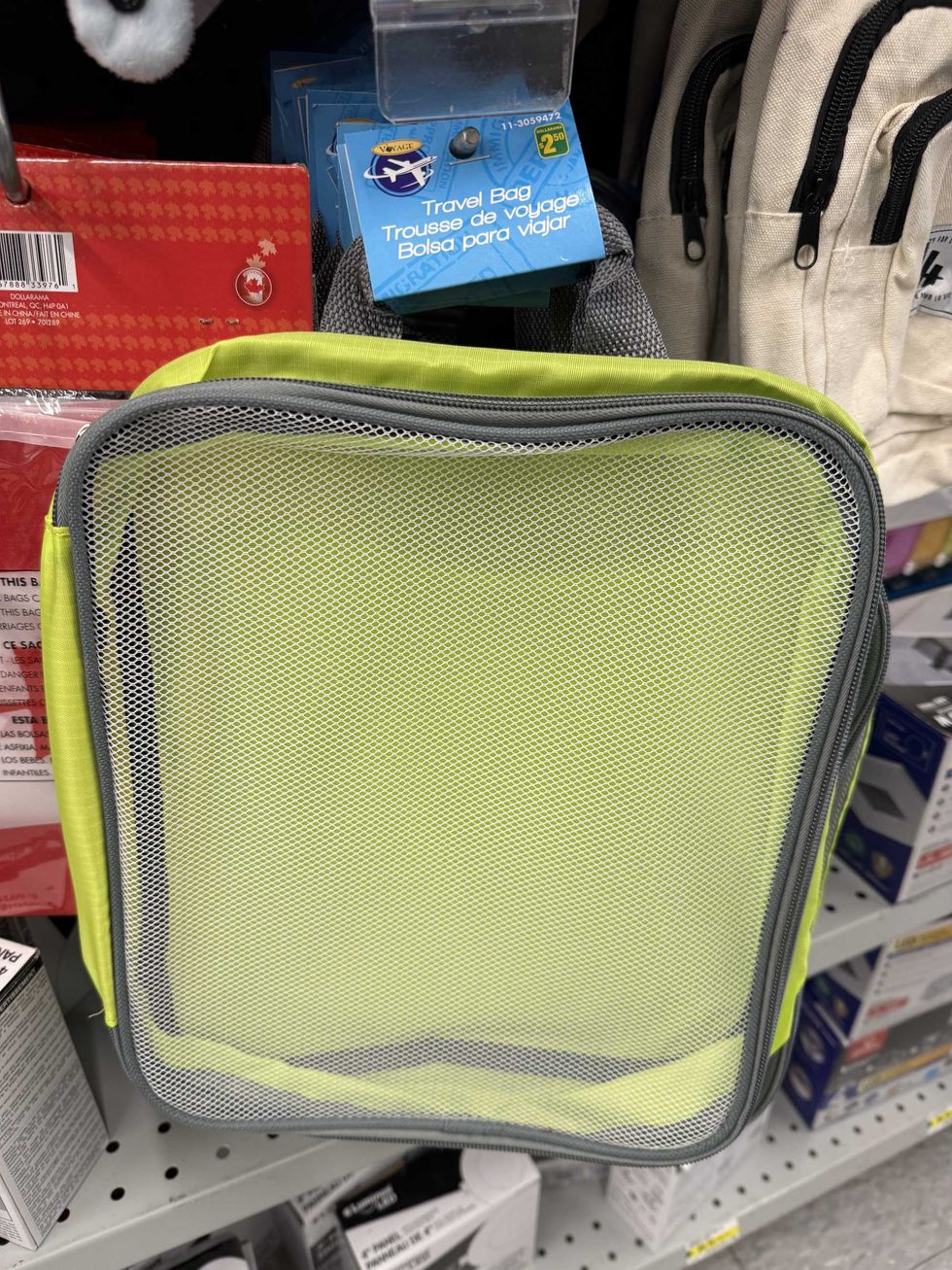 A green bag with a see-through front and a label that says travel bag.