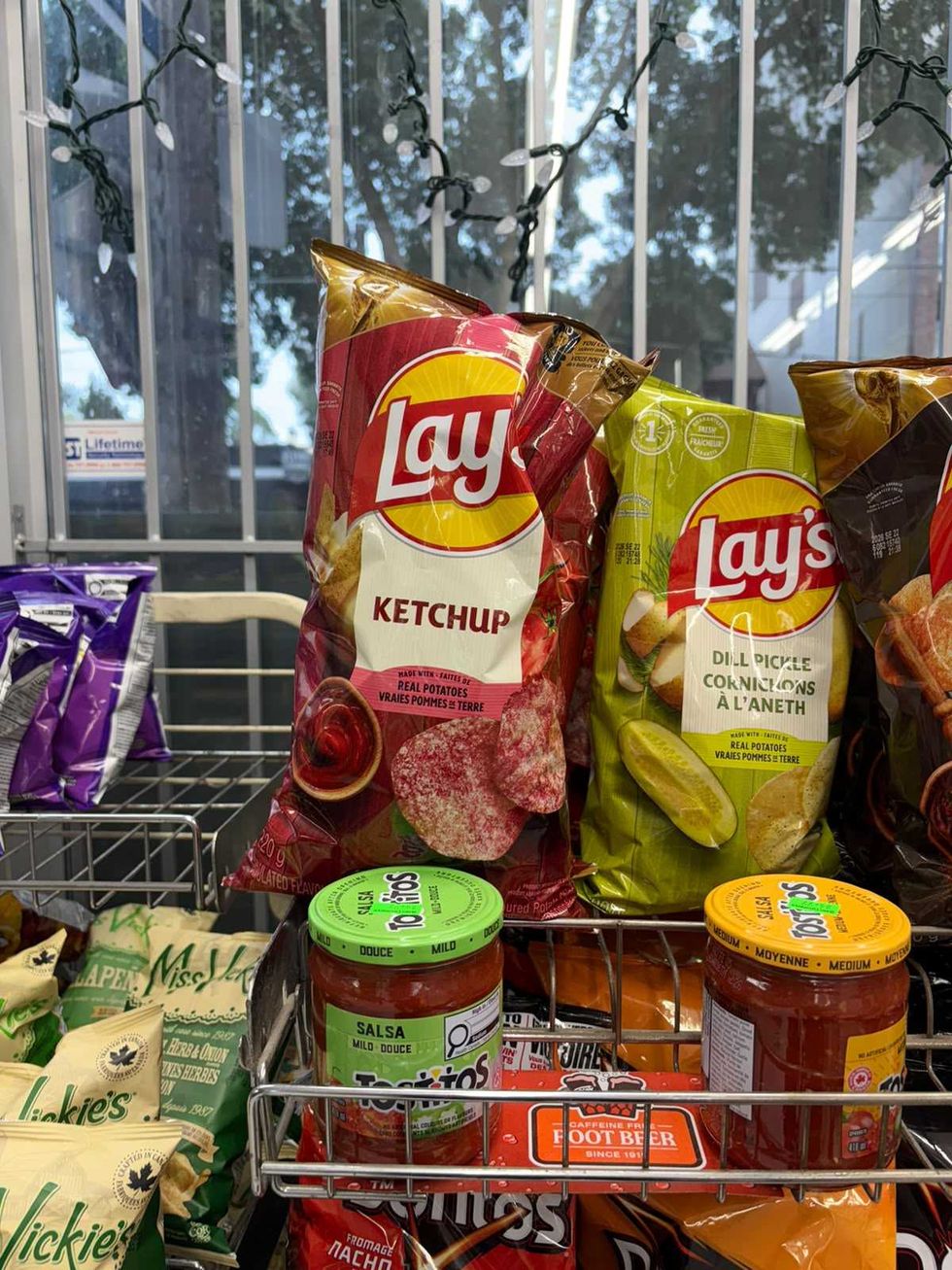 A grocery aisle with ketchup chips, dill pickle chips, and salsa.