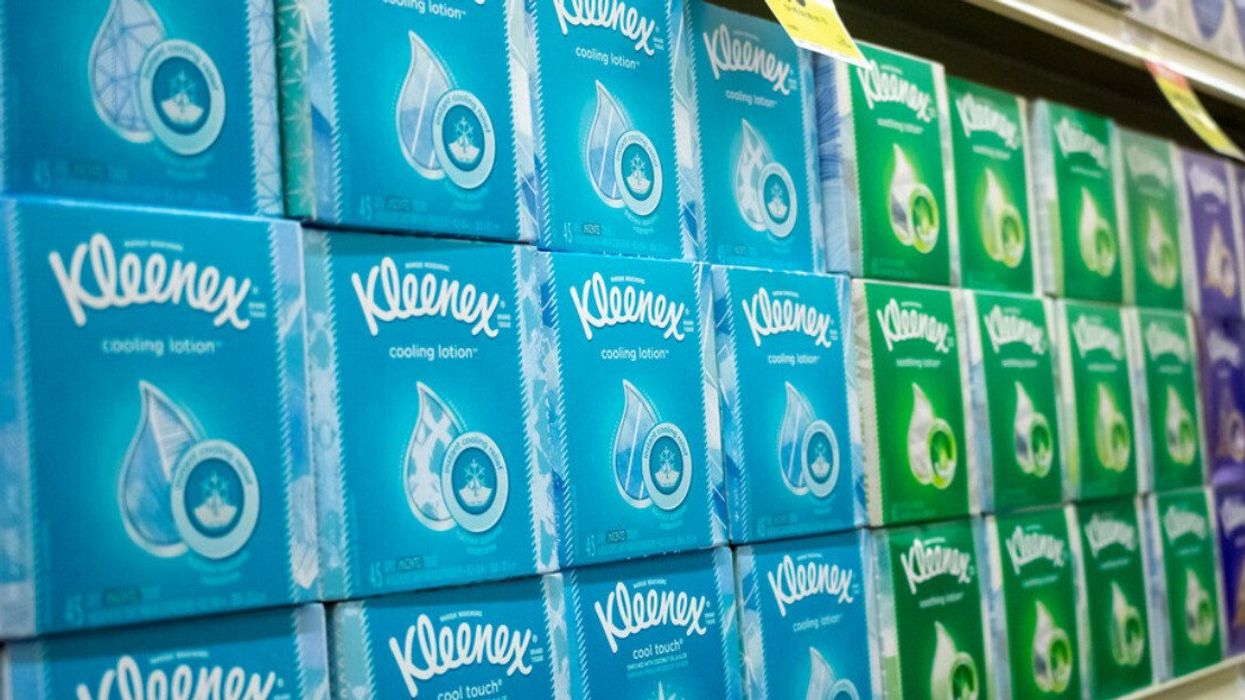 A grocery store shelf full of Kleenex tissue boxes.